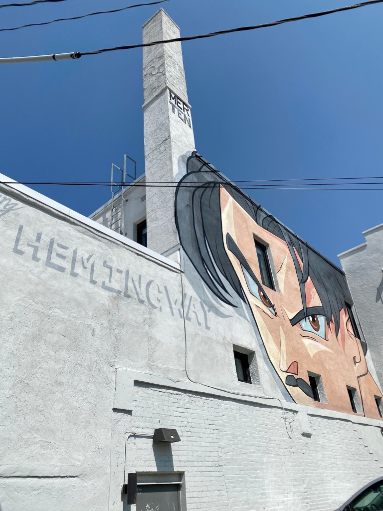 Portrait of a young Ernest Hemingway by artist Jake Merten at the rear of the Hemingway Building