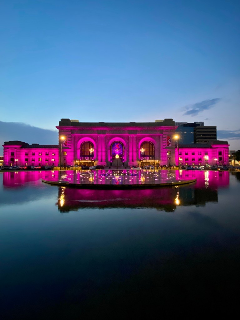 Photo of Kansas City's Union Station lit up at night. The building is lit up in pink as the movie 'Barbie' was being shown at the Station's movie theater at the time. 